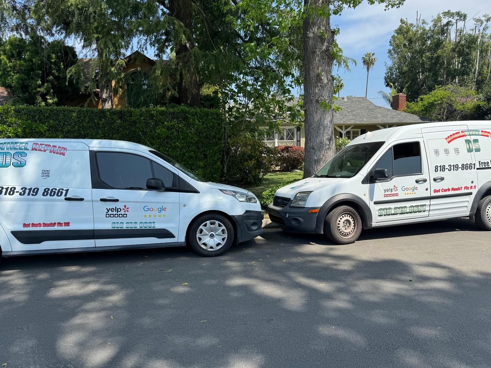 Two D S Mobile Wheel Repair vans parked on a residential street in Los Angeles